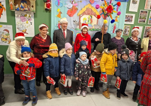 dzieci z prezentami i seniorami pozują do zdjęcia