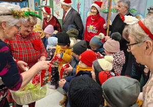 seniorzy wręczają dzieciom prezenty