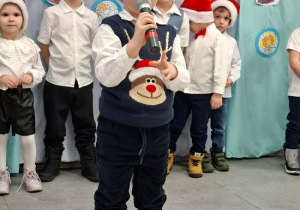 chłopiec w czapce Mikołaja mówi wiersz