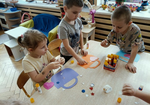 dzieci wykonują papierowe torebki i naklejają naklejki