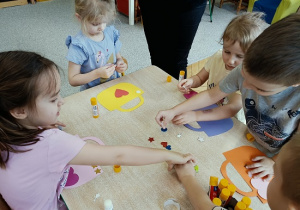 dzieci wykonują papierowe torebki i naklejają naklejki