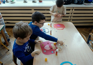 dzieci wykonują papierowe torebki i naklejają naklejki