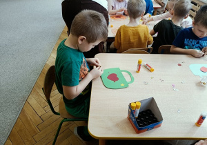 dzieci wykonują papierowe torebki i naklejają naklejki