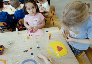 dzieci wykonują papierowe torebki i naklejają naklejki