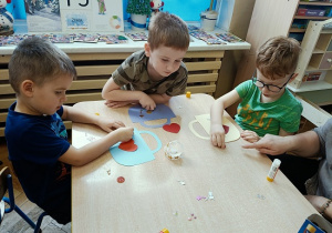 dzieci wykonują papierowe torebki i naklejają naklejki