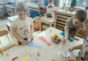 dzieci wykonują papierowe torebki i naklejają naklejkidzieci wykonują papierowe torebki i naklejają naklejki