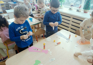 dzieci wykonują papierowe torebki i naklejają naklejki