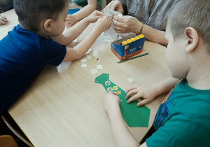 dzieci wykonują papierowe torebki i naklejają naklejki