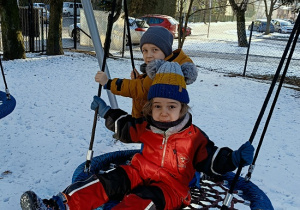 chłopcy bujają się na huśtawce