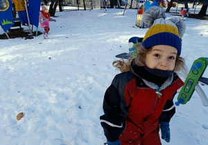 chłopiec w zimowym ubraniu spaceruje po śniegu