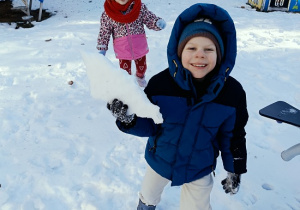 chłopiec rzuca śniegiem