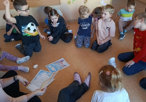 dzieci słuchają bajki czytanej przez nauczycielkę