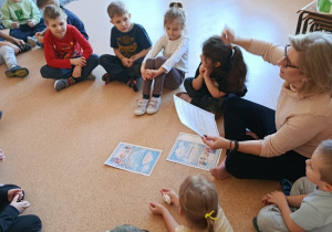 dzieci słuchają bajki czytanej przez nauczycielkę