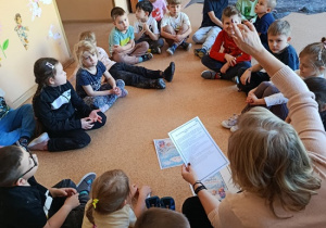 dzieci słuchają bajki czytanej przez nauczycielkę