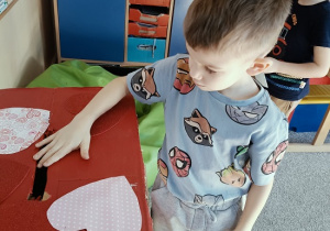 chłopiec wrzuca do papierowej skrzynki swoją walentynkę