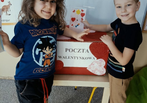 chłopcy wrzucają do skrzynki papierowe walentynki