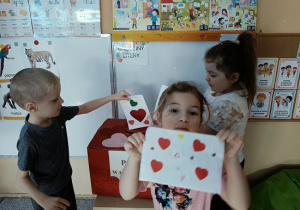 dzieci wrzucają do skrzynki papierowe walentynki