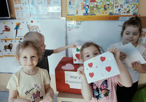 dzieci wrzucają do skrzynki papierowe walentynki
