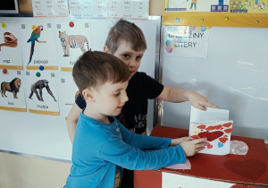 chłopcy wrzucają do skrzynki papierowe walentynki