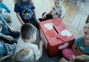 dzieci wrzucają do skrzynki papierowe walentynki