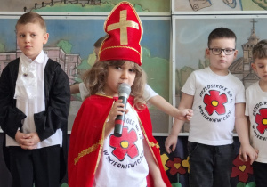 chłopiec w stroju biskupa prezentuje wiersz