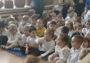 przedszkolaki w strojach galowych obserwują występy dzieci