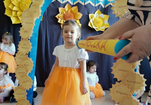 dziewczynka zostaje pasowana na przedszkolaka za pomocą kredki