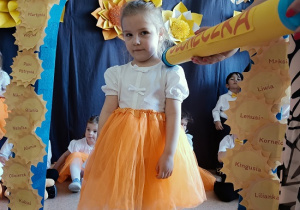 dziewczynka z dyplomem i maskotką pozuje do zdjęcia