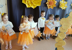 dzieci pozują do zdjęcia z dyplomami i maskotkami