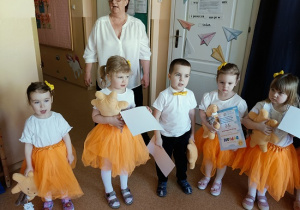 dzieci pozują do zdjęcia z dyplomami i maskotkami