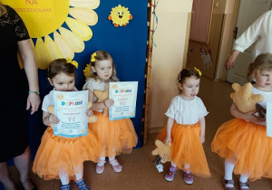 dzieci pozują do zdjęcia z dyplomami i maskotkami