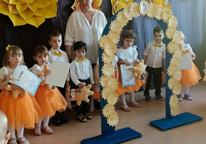 dzieci pozują do zdjęcia z dyplomami i maskotkami