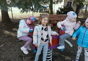 dziewczynki bujają się na huśtawce na placu przedszkolnym