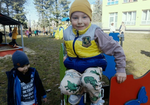 chłopiec siedzi na domku drewnianym