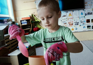 chłopiec sieje owies w doniczce