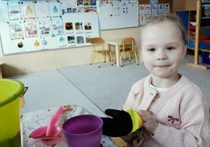 dziewczynka sieje owies w doniczce