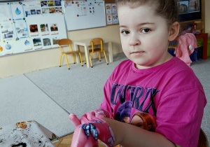 dziewczynka sieje owies w doniczce