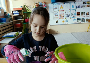 dziewczynka sieje owies w doniczce