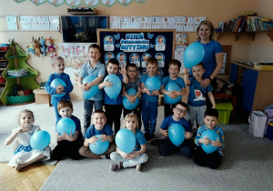 dzieci w niebieskich koszulkach trzymają balony