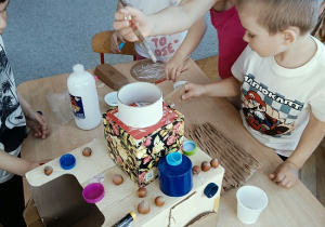 dzieci konstruują z pudełek i plastiku samochód