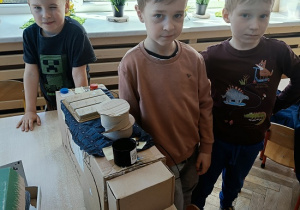 chłopcy prezentują auto z pudełek