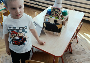 chłopiec prezentuje auto z pudełek