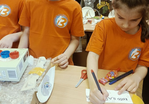 dzieci wykonują auta z pudełek i plastiku