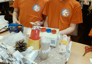 dzieci wykonują auta z pudełek i plastiku