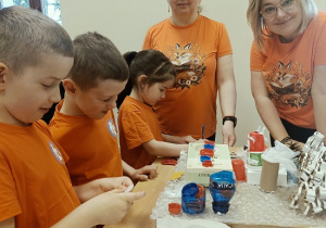 dzieci wykonują auta z pudełek i plastiku