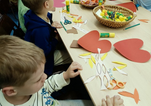 dzieci wykonują laurkę dla mamy