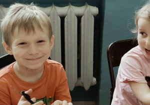dzieci wykonują laurkę dla mamy