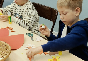 dzieci wykonują laurkę dla mamy