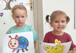 dziewczynki trzymają obrazki w rękach