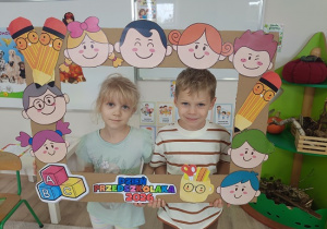 dzieci w ramce pozują do zdjęcia